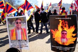 Pro-Tibetan protesters hold placards rem
