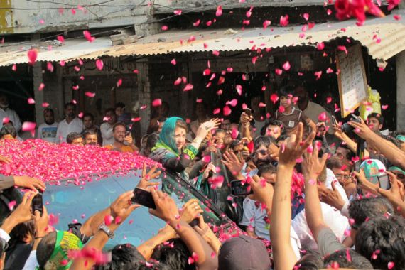Maryam Nawaz is covered in rose petals as she encourages voters in Lahore [Asad Hashim/Al Jazeera]