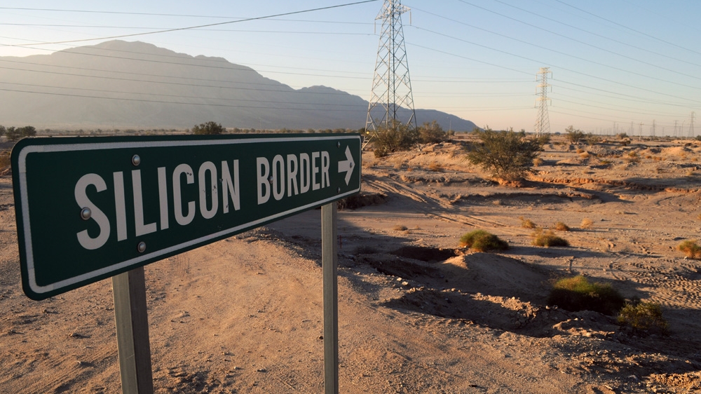 A roadside sign points towards an undeveloped industrial park, known as Silicon Border, at the base of the Centinela mountain [Joe Jackson /Al Jazeera] 