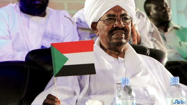 NCP presidential candidate, Sudan''s President al-Bashir holds a Sudan national flag during a campaign rally in Omdurman