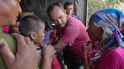 Anil Thing (centre) delivers aid to villagers [Mark Scialla/Al Jazeera] 