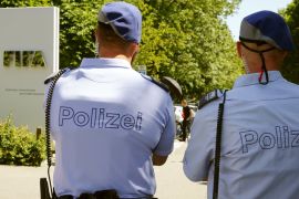 Swiss police officers stand in front of the entrance of the FIFA headquarters in Zurich