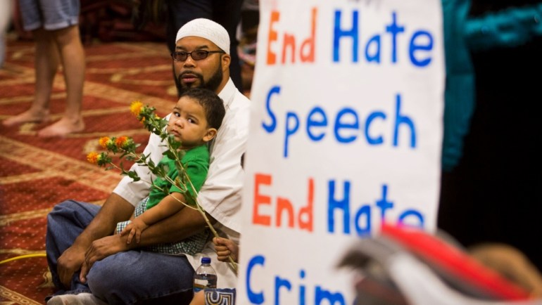 Attendees listen as speakers from different faiths speak at an interfaith rally titled 
