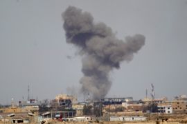 A plume of smoke rises above a building during an air strike in Tikrit