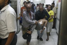 People carry a man at a hospital after he was injured by a shelling during clashes between Houthi militants and pro-government militants in Yemen''s southwestern city of Taiz