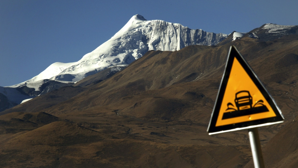 A road sign is seen in front of the Kharola glacier, west of Lhasa Tibet Autonomous Region [File: Nir Elias/Reuters]