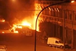 View shows vehicles on fire outside Splendid Hotel in Ouagadougou
