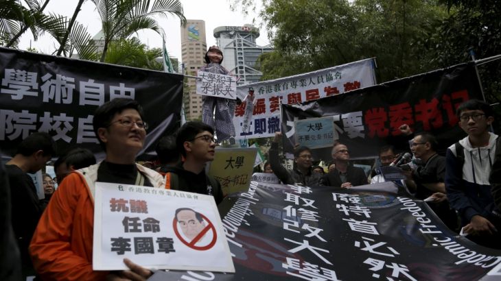 Demonstrators hold up signs to protest against the appointment of a pro-Beijing professor as the chairman of the governing council of the University of Hong Kong, in Hong Kong, China