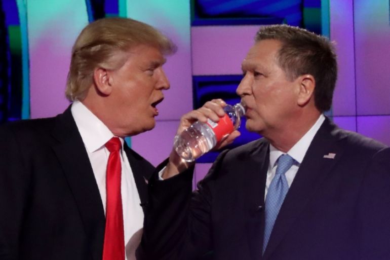 Republican U.S. presidential candidate Trump talks with rival Kasich during a commercial break at the debate in Miami
