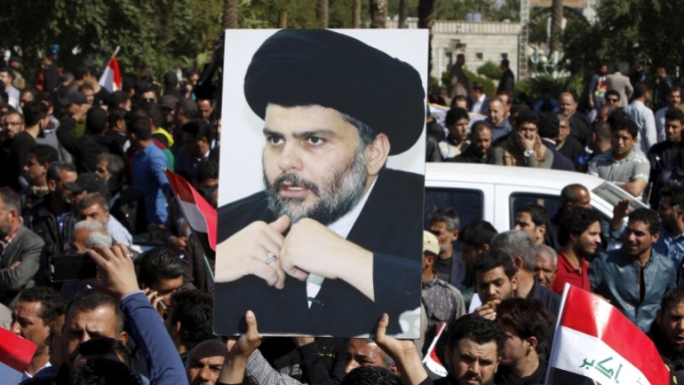 A demonstrator holds a picture of Moqtada al-Sadr during a demonstration in Baghdad [REUTERS]
