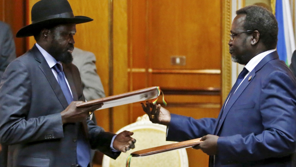 File photo shows South Sudan's rebel leader Riek Machar and South Sudan's President Salva Kiir exchanging signed peace agreement documents in Addis Ababa