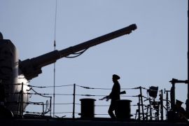 A Russian Navy member stands guard on the deck of a Russian nuclear-powered missile cruiser docked in the Cypriot port of Limassol [AFP]