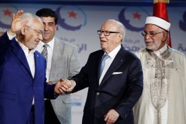 Tunisian President Beji Caid Essebsi (R) and Rached Ghannouchi, leader of the Islamist Ennahda movement, gesture during the congress of the Ennahda Movement in Tunis,Tunisia