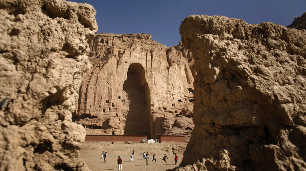 Afghan boys play football in front of the gaping niche where a giant Buddha statue used to stand in Bamiyan [Goran Tomasevic/Reuters] 