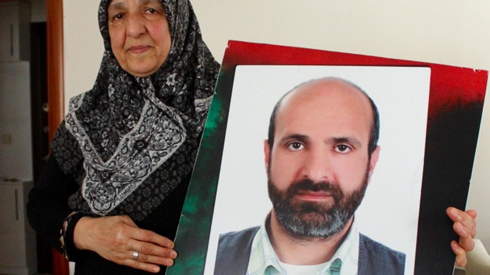 Vasfiye holds a photo of her son, Cengiz Akyuz [Courtesy of Cengiz Akyuz's family]