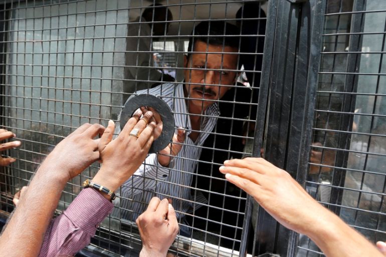 A convict in connection with a riot in Gujarat in 2002 is seen inside a police vehicle at a court after the sentencing in Ahmedabad