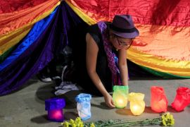 A gay rights activist places a candle during a rally in Cali, Colombia, in support of the victims of the Orlando Pulse nightclub shooting