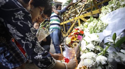Indian family members place floral tributes near the site of the terrorist attack in Dhaka, Bangladesh [EPA]