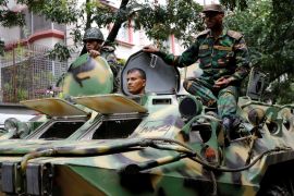Army soldiers atop an armored military vehicle drive near the Holey Artisan restaurant after Islamist militants attacked the upscale cafe in Dhaka