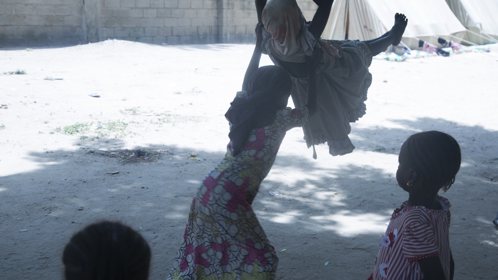 Children play on a swing at the safe house [Chika Oduah/Al Jazeera]