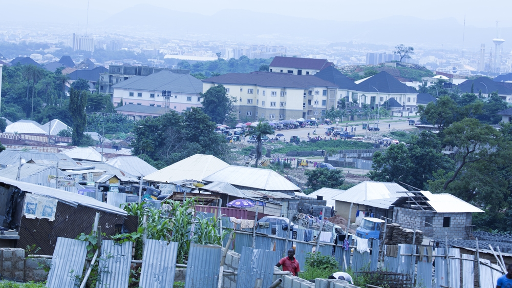 The low-income community of Kpaduma overlooks new residential estates in Abuja [Chika Oduah/Al Jazeera]