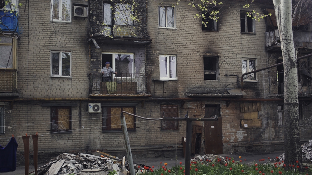 Viktor Brezhnev lives in Kievsky, close to the frontline. From his balcony, he looks out on to his charred neighbourhood. In September of 2014, his apartment was shelled and totally destroyed. In late April 2015, he returned to try to rebuild it [Kyrre Lien/Al Jazeera] 