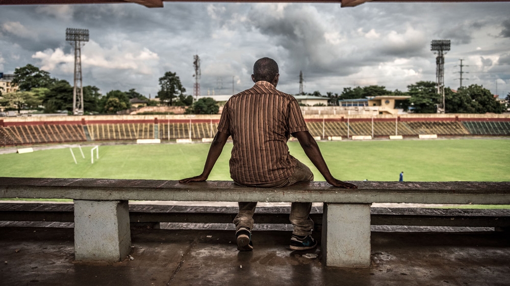 Abdoulaye Diallo, who was shot in the stomach during the September 28 massacre, looks out over the playing field [Tommy Trenchard/Al Jazeera] 
