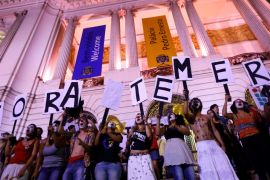 Protesters  in Rio de Janeiro hold placards against Brazil's President Michel Temer, which read "Out Temer" [Reuters]