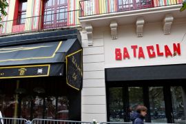 People walk past the Bataclan Cafe and the new facade of the Bataclan concert hall almost one year after a series of attacks at several sites in Paris