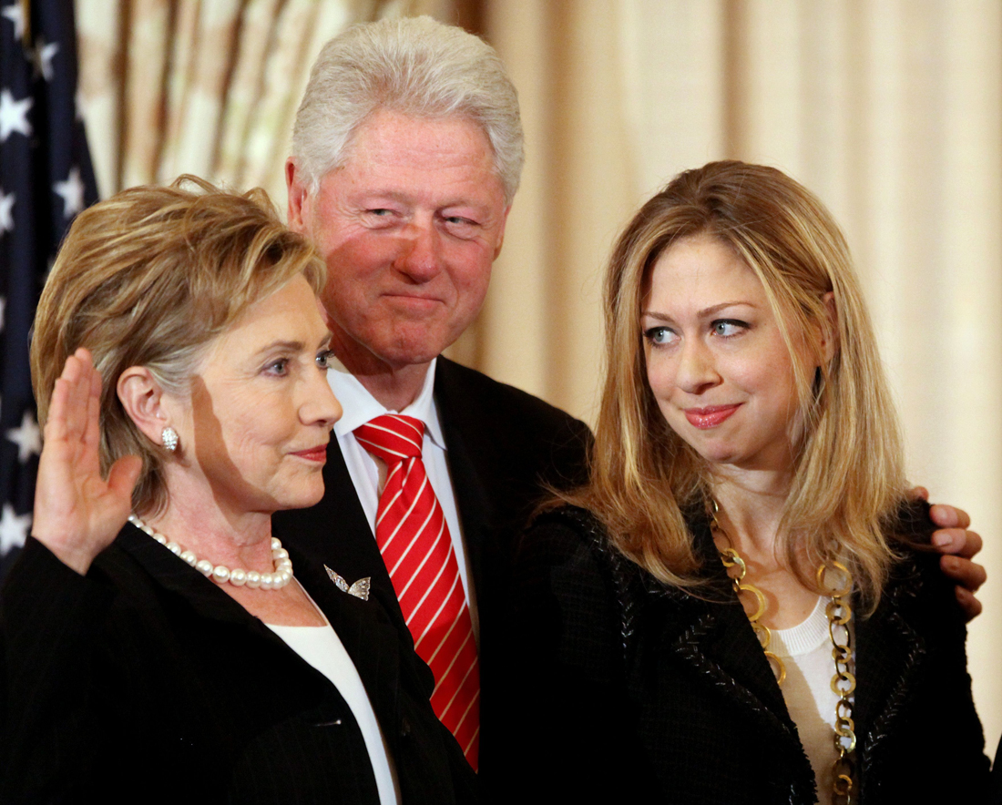 Former president Bill Clinton and daughter Chelsea Clinton look on during a ceremonial swearing-in for Secretary of State Hillary Rodham Clinton in 2009 [Haraz N Ghanbari/AP]