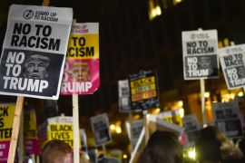 People hold placards at an anti-racism protest against U.S. President-elect Donald Trump outside of the U.S. Embassy in London