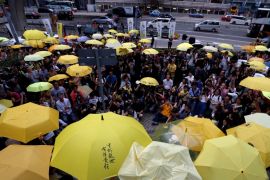 Pro-democracy protesters carrying yellow umbrellas stage a three-minute silence outside government headquarters in Hong Kong to mark the second anniversary of the movement
