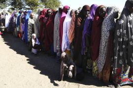 Women who have fled violence in Nigeria queue for food at a refugee welcoming center in Ngouboua