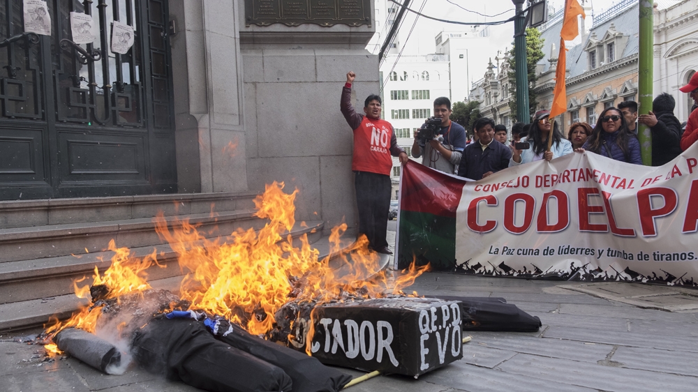 Protestors burn a doll that represents Evo Morales [Eline van Nes/Al Jazeera]