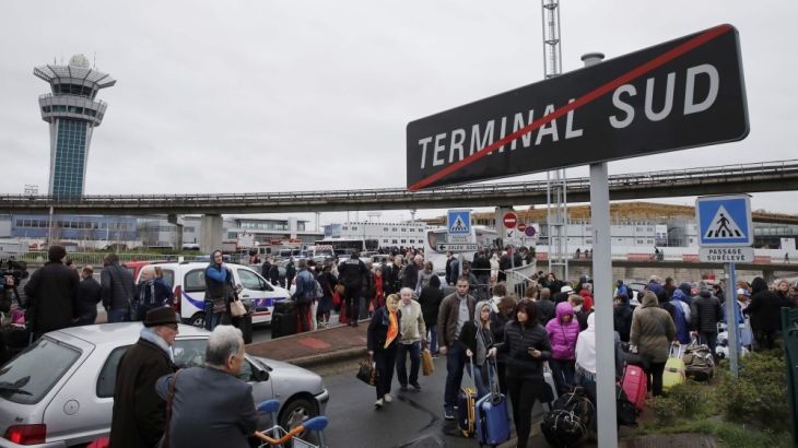 Passengers wait at Orly airport southern terminal after shooting incident near Paris