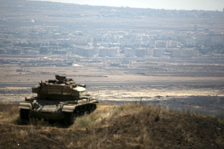 The Syrian area of Quneitra is seen in the background as an out-of-commission Israeli tank parks on a hill, near the ceasefire line between Israel and Syria, in the Israeli-occupied Golan Heights
