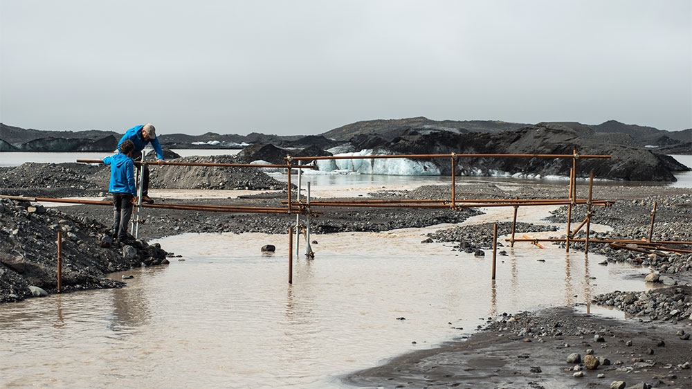 
Guides work to build a new bridge across a river draining from Falljokull glacier ahead of the summer season when meltwater run-off increases [Alexander Lerche/Al Jazeera]
