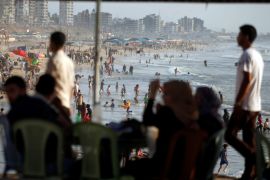 Palestinians spend time on a beach in a warm weather in Gaza City