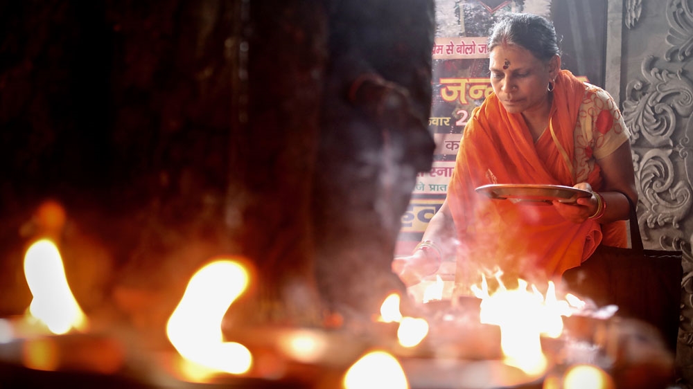 A woman worships at the Monkey Temple in New Delhi, India. In 1947, when independent India and Pakistan were created, Hindu, Sikh and Muslim mobs attacked each on the streets of the capital and other places throughout the Indian subcontinent [Steve Chao/Al Jazeera] 