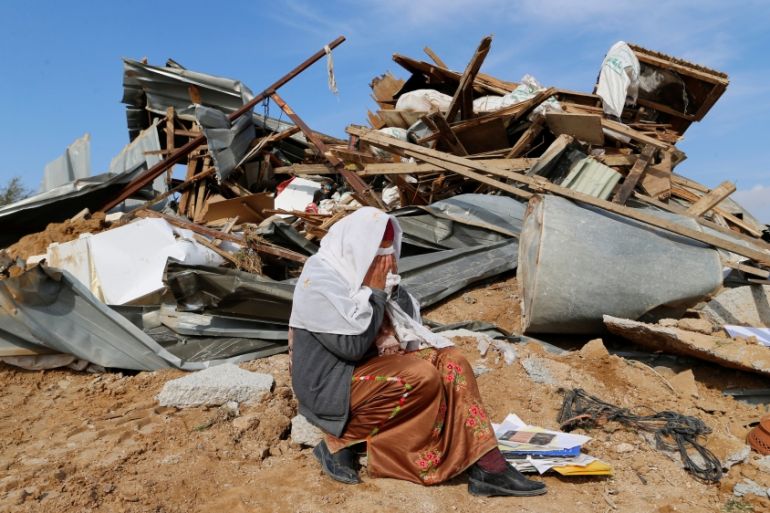 An Arab Israeli woman sits next to ruins from her dwellings which were demolished by Israeli bulldozers in Umm Al-Hiran, a Bedouin village in Israel''s southern Negev Desert