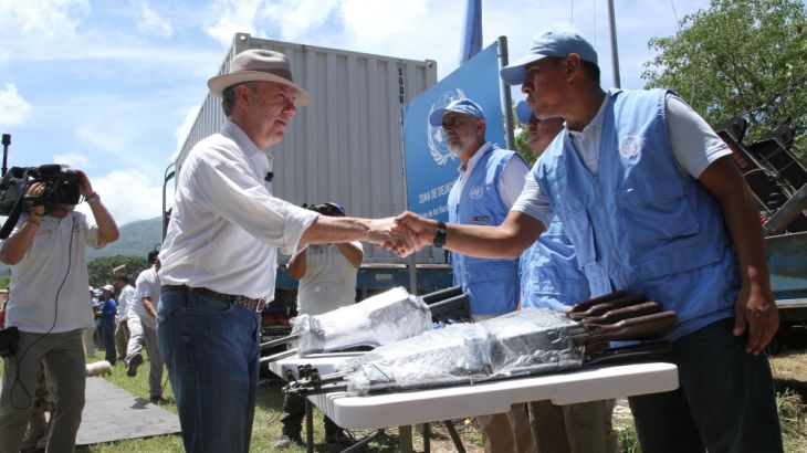Colombia''s President Juan Manuel Santos greets an observer of the UN as the last container with weapons delivered by the rebels of the FARC is turned in, in La Guajira