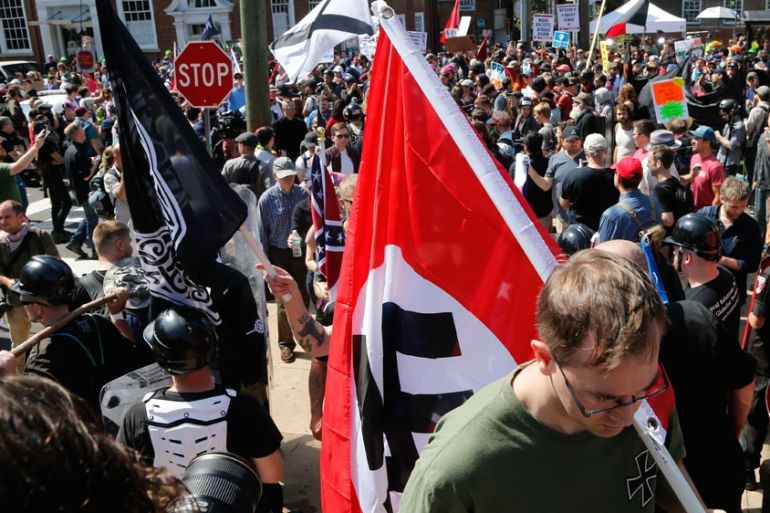 A white supremacist carries a NAZI flag into the entrance to Emancipation Park in Charlottesville, Virginia.