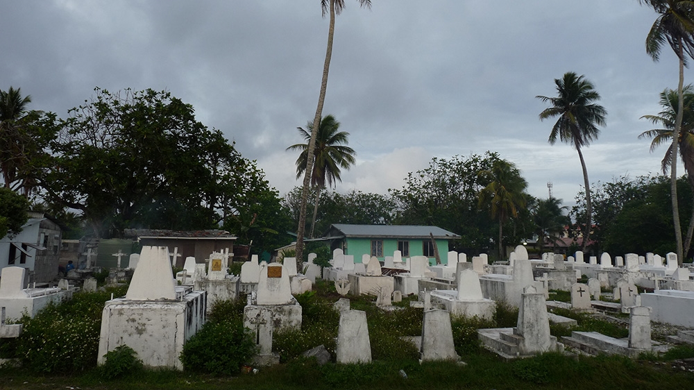 
Known as a large ocean state, the Republic of the Marshall Islands has just 181 square kilometres of land but nearly two million square kilometres of sea. Forced relocation and demographic shifts after World War II have made crowding and urbanisation a problem in the low-lying Micronesian nation. Here, in downtown Majuro, the capital, the living and the dead vie for space [Jon Letman/Al Jazeera]

