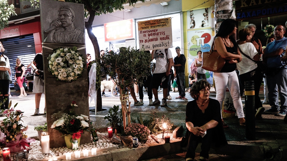 Magda sits in front of the memorial of Pavlos Fyssas on September 17, 2016 [Alexandros Michailidis/SOOC/Al Jazeera]