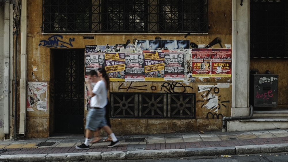 In September 2017, Athenians walk past posters calling for protests to commemorate Pavlos' murder [Nick Paleologos/SOOC/Al Jazeera]