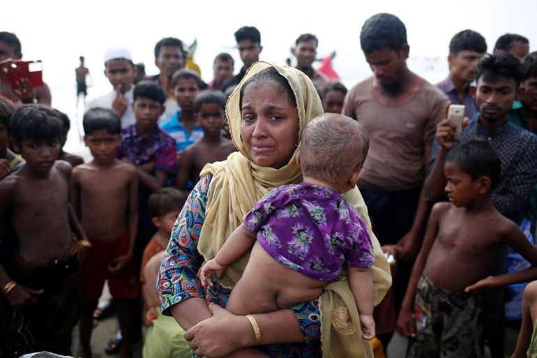 A Rohingya woman with a baby in her arms cries after crossing the Bangladesh-Myanmar border.