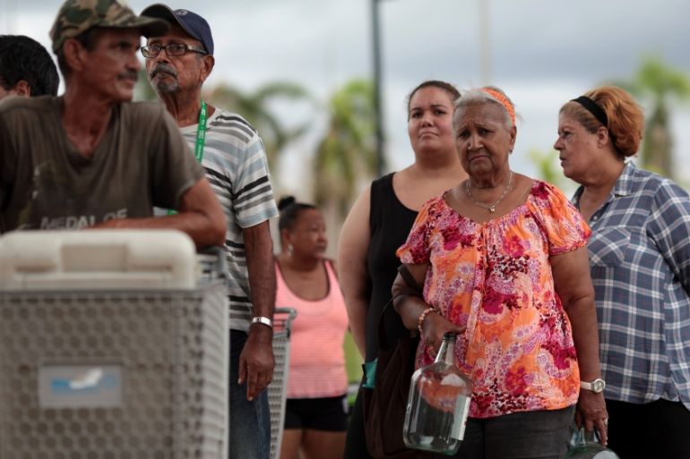 Local residents wait in line during a water distribution in Bayamon following damages caused by Hurricane Maria in Carolina, Puerto Rico
