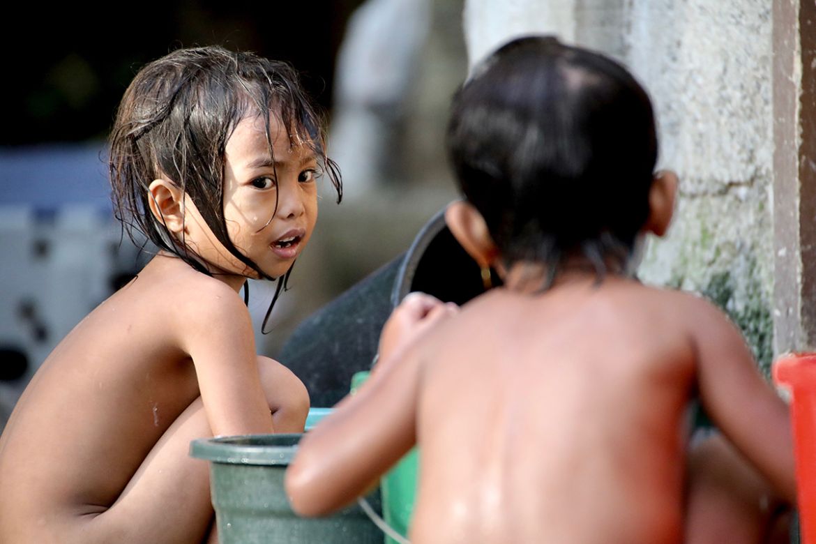Young children wash themselves outside an evacuation centre near Marawi. The government can’t say how long it will take to rebuild the city and when residents can return home.