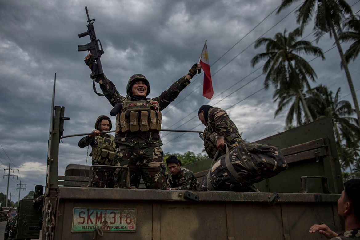 A government soldier waving the Philippine flag as they get ready to leave the battle against IS-inspired militants on October 20, 2017 in Saguiaran town in Lanao del Sur, southern Philippines. Presid