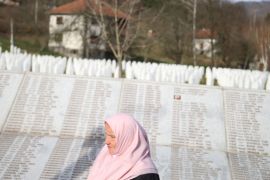A woman walks past the Memorial plaque with the names of people killed in the Srebrenica massacre at the Memorial centre Potocari near Srebrenica